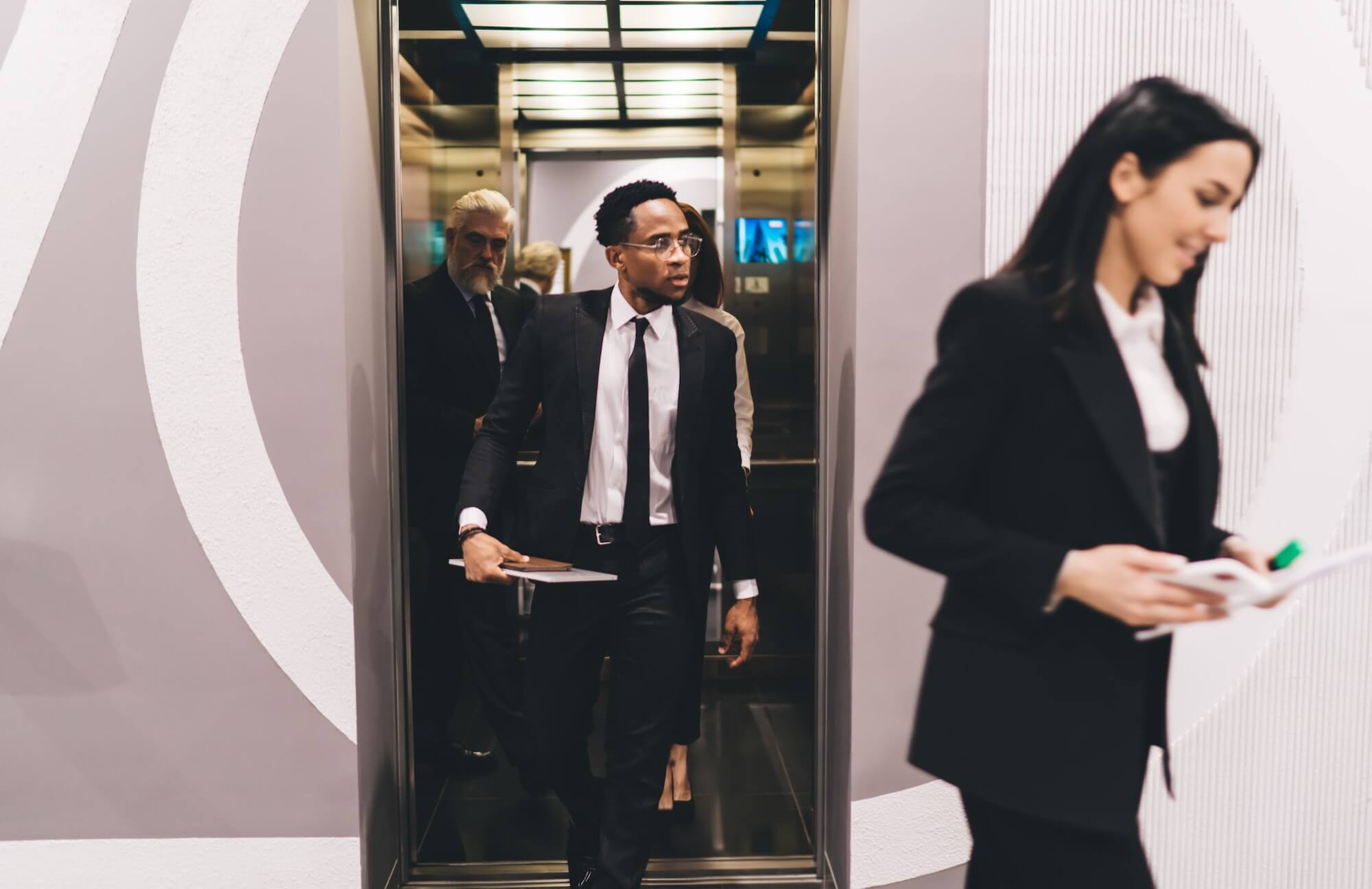 Multiethnic colleagues at work leaving elevator
