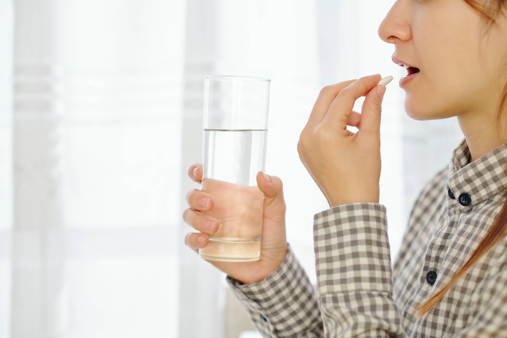 Woman taking birth control tablet